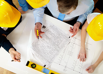 Aerial view of engineers and construction crew reviewing blue prints